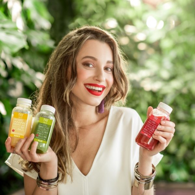 Usmiata žena držiaca v ruke detoxikačne max juices od EasyDiet