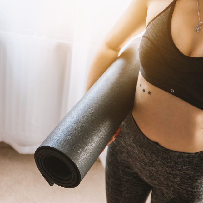 žena v športovom s podložkou na cvičenie