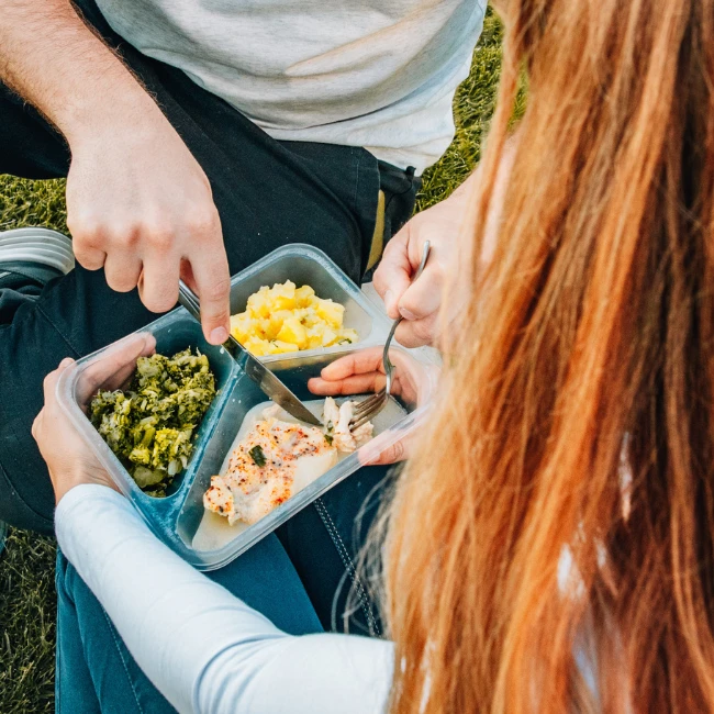 Das Paar isst eine gesunde und ernährungsphysiologisch ausgewogene Mahlzeit in einer Box von EASYDIET