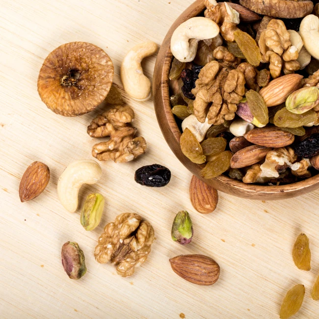 Verschiedene Arten von Nüssen und Trockenfrüchten in einer Schüssel als gesunder Snack für die Feier