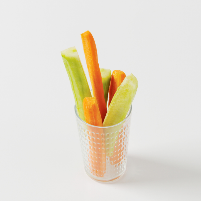 Kúsky mrkvy a uhorky v sklenenom pohári predstavujú zdravý snack