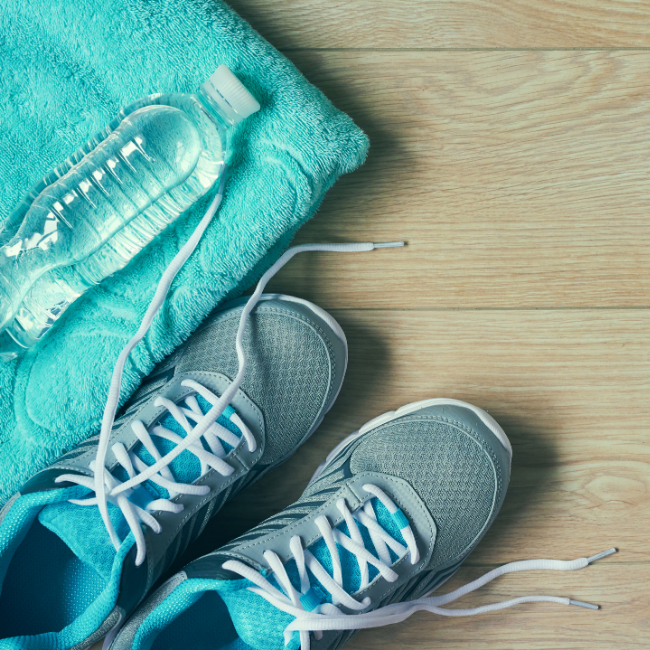 Modré tenisky, uterák a fľaša s vodou pripravené na spaľovanie kalórií