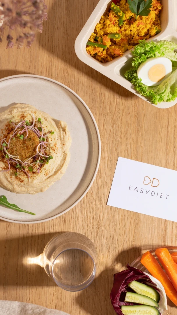 Gesundes EasyDiet-Essen: Hummus mit Falafel und Couscous mit Salat auf einem Holztisch.