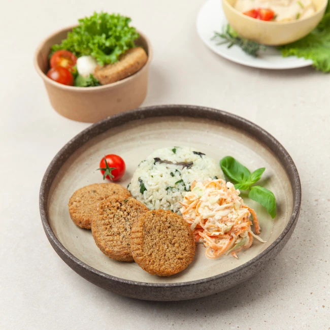 Vegetariánske jedlo na tanieri a v krabičke - zeleninové placky s ryžou, kapustový šalát